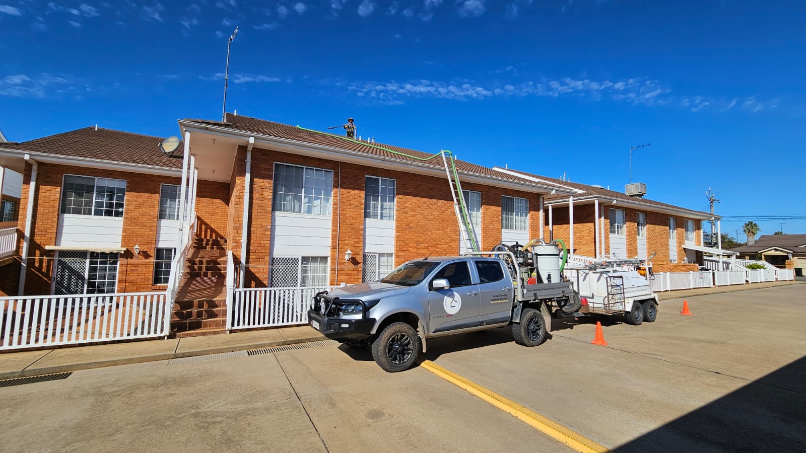 Commercial multi-residential gutter vacuuming operations on large apartment building